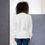 Thumbnail: Back view of a lady wearing a white unisex long sleeve sweatshirt with cowboys design and Biblical inscription