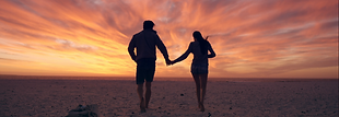 happy-couple-walking-towards-sunset-on-e