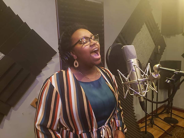 Young woman singing in a recording studio