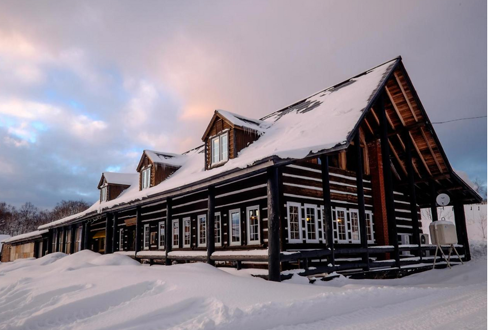 Margos Garden, a wooden ski lodge in the countryside outside Otaru, Hokkaido, Japan with snow on the roof.