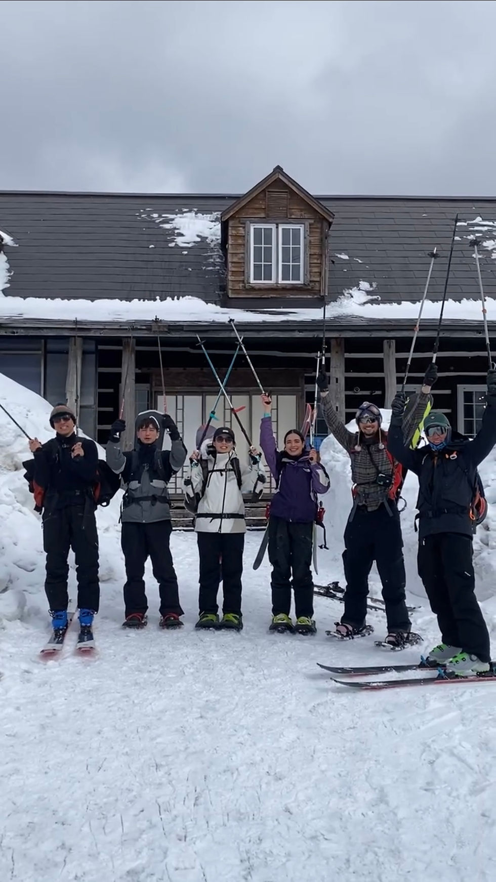 Big group of backcountry skiers and snowboarders in front of Margos Garden, a farm outside of Otaru, Hokkaido, Japan, with snowshoes and skins.