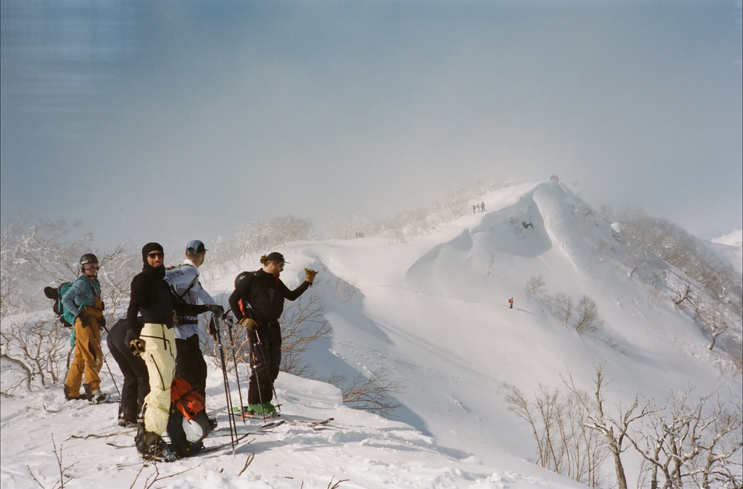 Group of backcountry skiers smiling on a mountain in Hokkaido, Japan.