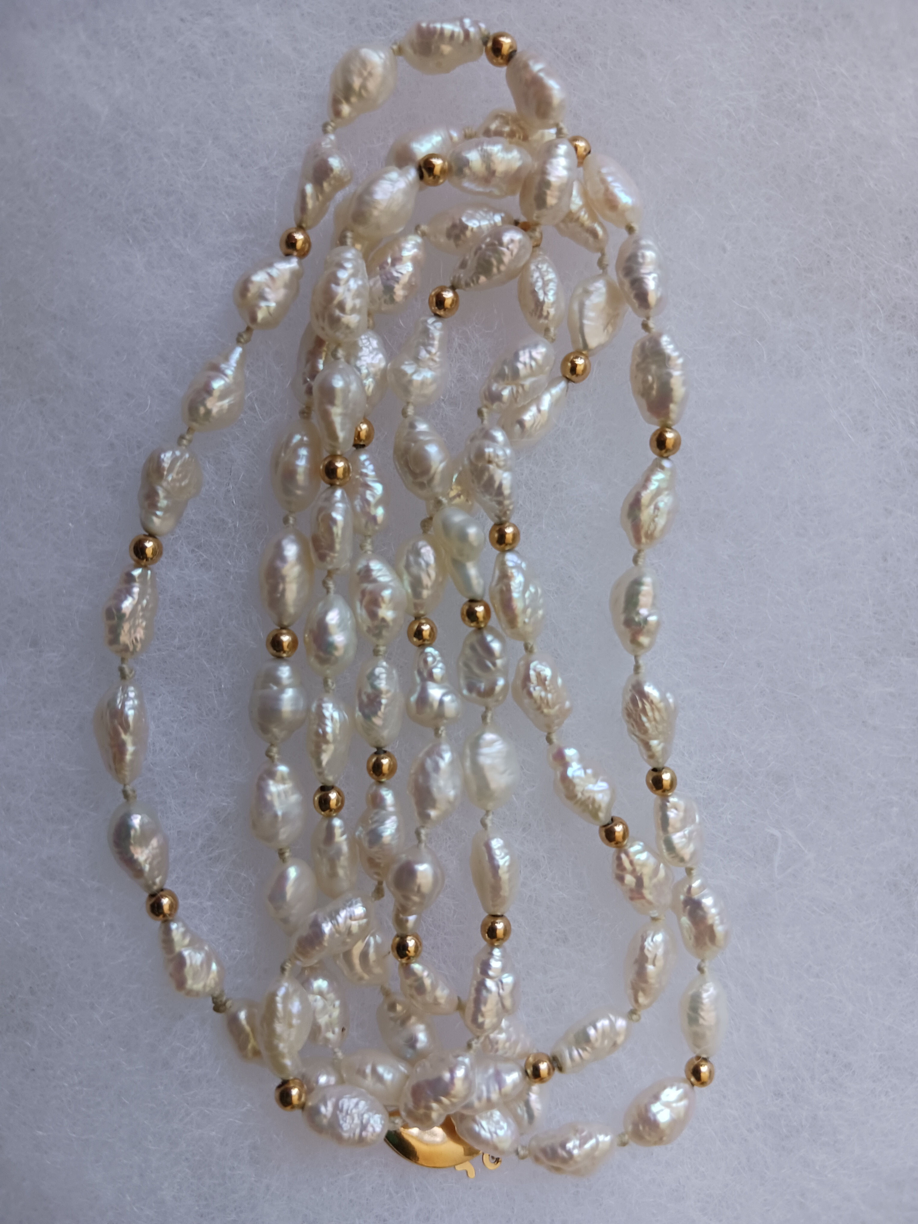 Rice pearl and gold bead opera length necklace.