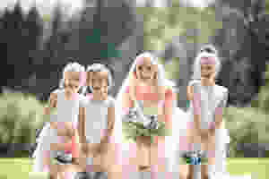 Bride and young bridesmaids laughing