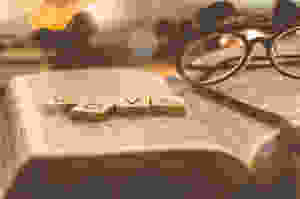 Open book with glasses and scrabble words spelling the word Love