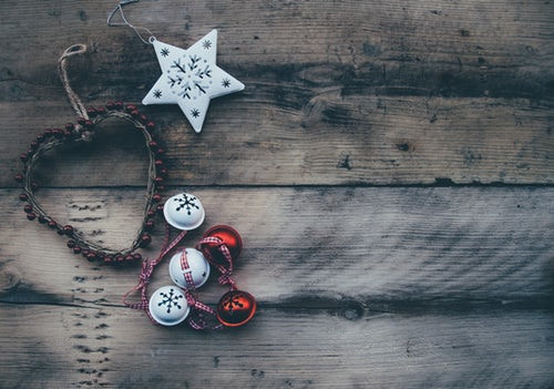 Christmas decorations, bells, star and heart on wooden background