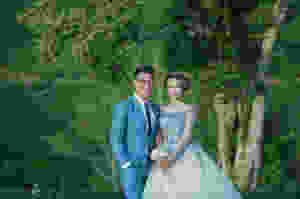 Smiling bride and groom in matching blue wedding dress and suit
