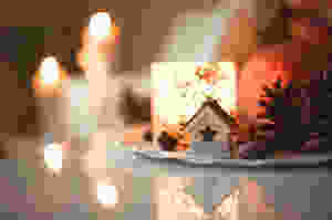 Small house with cut-out star shape, pine cones and candle table decoration