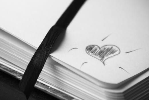 doodle of a heart in black pencil in the corner of the page in a notebook