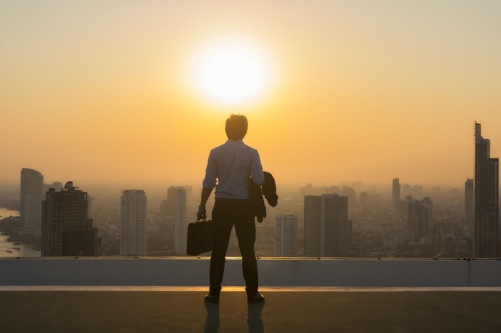 rear-view-man-standing-by-modern-buildings-against-sky-sunset.jpg