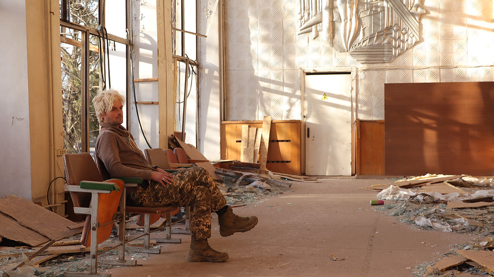 Shyvchyk, of the 423rd UAS Battalion, sits on a bench inside a severely damaged post office in Novomykolaivka, Zaporizhzhia region, March 12, 2026.