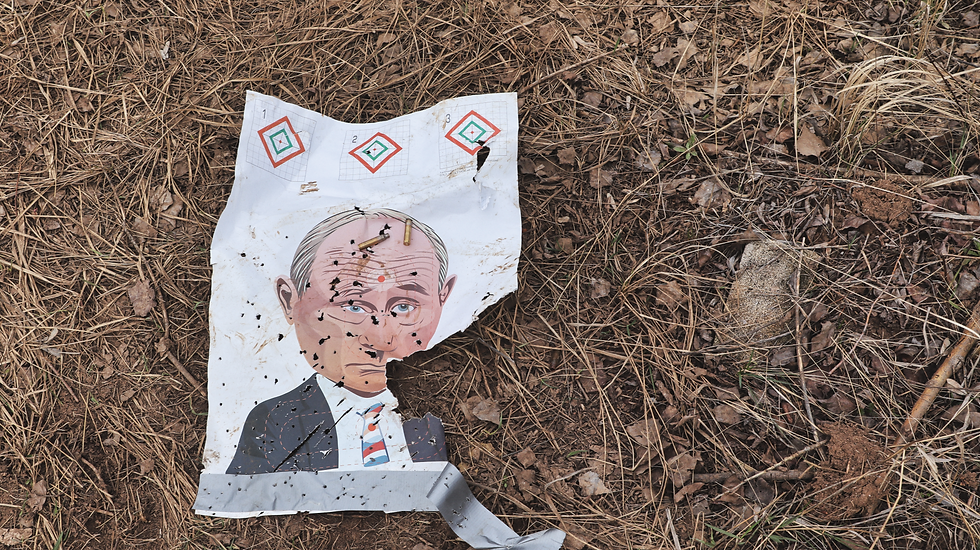 A shot-up paper target bearing the face of Russian President Vladimir Putin lies on the ground at a Khartia Brigade training site outside Kharkiv, April 2026.