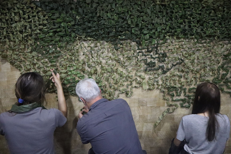 Volunteers at Shechznyk weave camouflage strips into nets for frontline protection.
