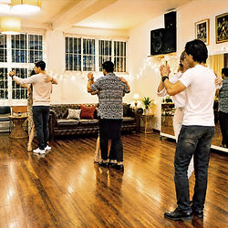 tango otra vez beginner class students dancing warm lighting