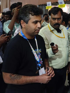 Neeraj Kumar speaking with the Tamil Nadu IT Minister at the Artifice: War Tactics booth during UMAGINE TN 2024.