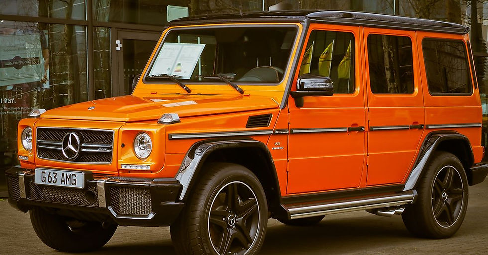 Credit Score Needed for an Auto Refinance - Bright orange Mercedes-Benz G Wagon parked in front of a building, showcasing luxury and style.