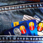 Close-up of a denim pocket with multiple credit cards, illustrating finance and fashion.