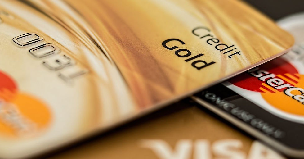 Stack of various branded credit cards focusing on gold card showing finance and cashless concept.