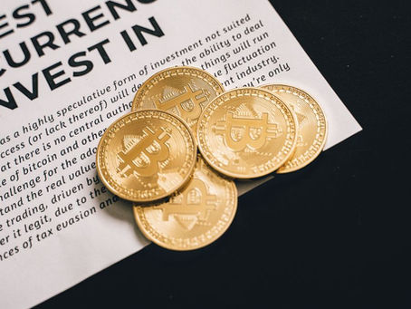 Close-up of Bitcoin coins on investment document promoting cryptocurrencies.