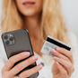 Close-up of a woman using a smartphone and credit card for online shopping.