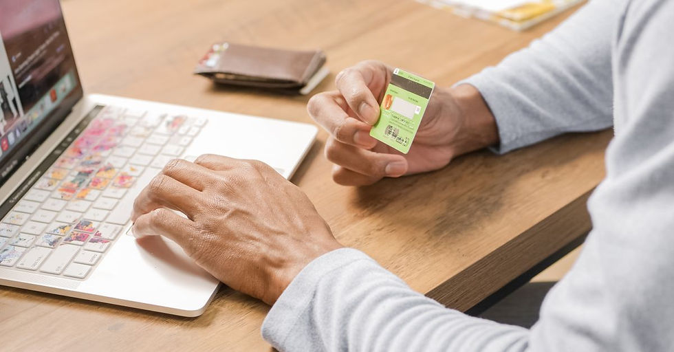 Person holds a credit card while browsing on a laptop, symbolizing convenient online shopping.