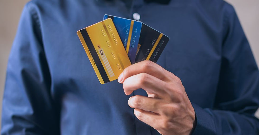 Person holding three credit cards, symbolizing finance, security, and e-commerce.