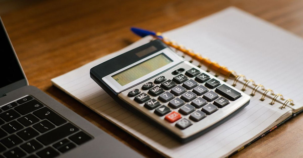 Credit Report - Calculator and open laptop on wooden desk, ideal for financial or accounting tasks.