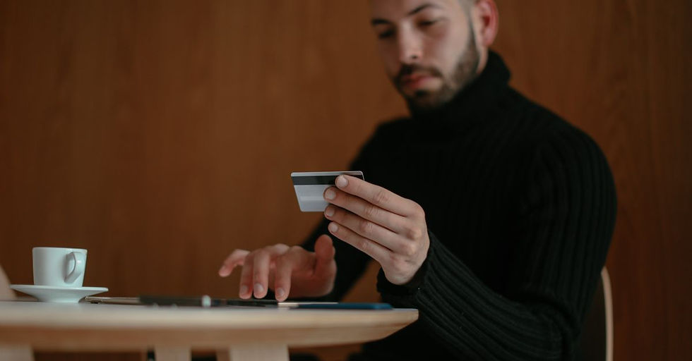 Focused man in café using tablet and credit card for online shopping.