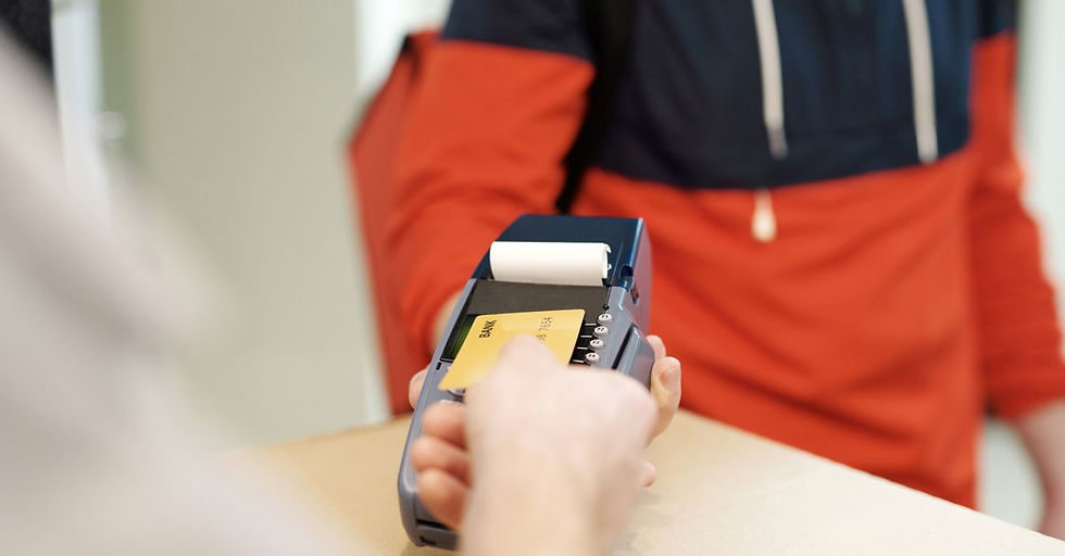 Close-up view of a contactless payment transaction using a credit card on a terminal device.