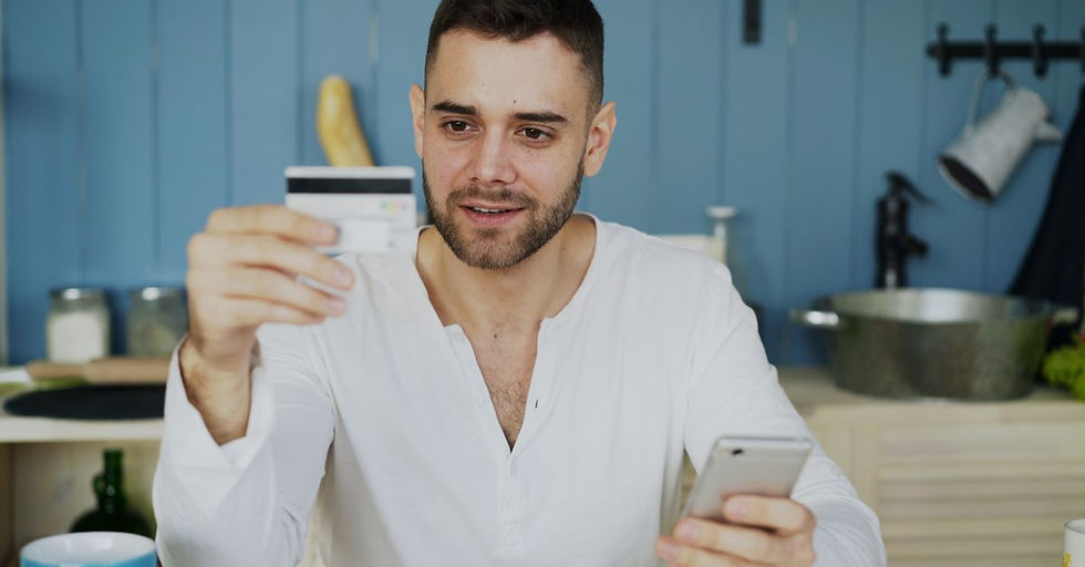 Man holding credit card and smartphone, shopping online at home.