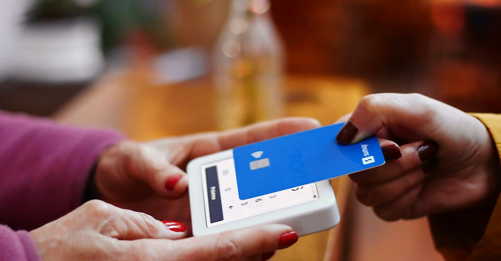 a person holding a credit card and a cell phone