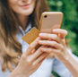 Woman using smartphone and credit card outdoors for online shopping.