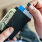 Close-up of a man's hands holding a wallet with cash and credit cards, indicating financial management.