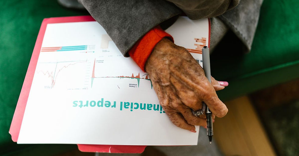 Credit Decisions - Close-up of an elderly woman holding a pen with a financial report.