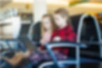 4 Data Safety Tips To Practice While Traveling two girls looking at laptop in airport