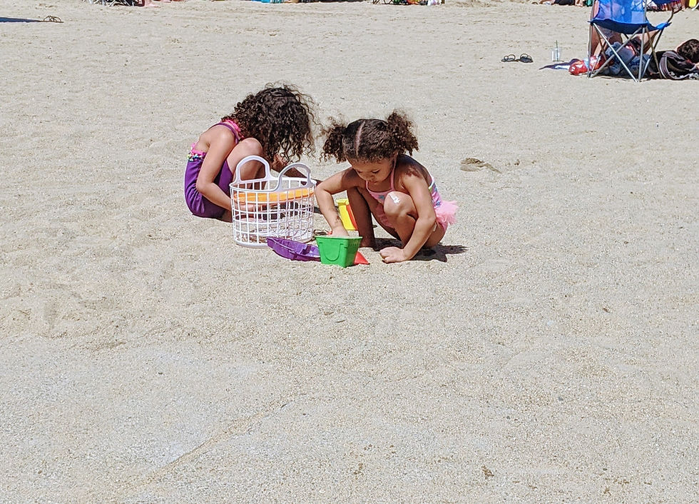 Free Beach day packing list printable two girls digging in the sand at the beach free printable beach packing list