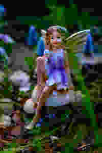 Fairy garden statue fairy with wings sitting on a mushroom