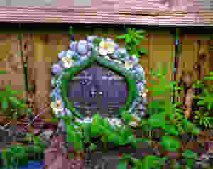 Fairy Garden door in garden by a fence with greenery