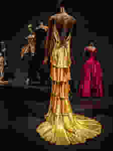 long-gold-open-backed-gown-as-part-of-paris-fashion-with-other-dresses-int-the-background