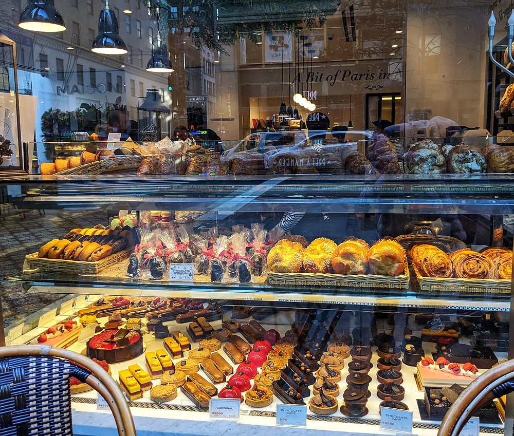 a-window-outside-a-bakery-with-rows-and-rows-of-pastries-and-breads