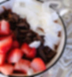 Smoothie bowl recipe DIY BARE strawberries, chocolate, coconut in a smoothie bowl on a table