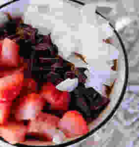 strawberries, chocolate, coconut in a smoothie bowl on a table