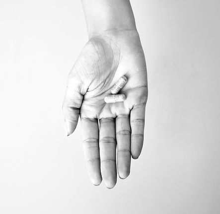 A woman holding 2 capsules of herbal sup