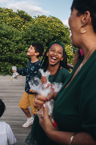 Laughing children holding treats at an outdoor event