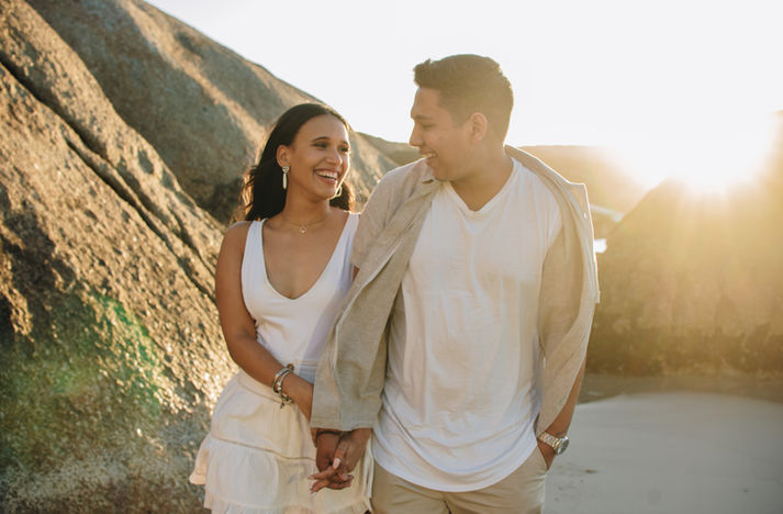 Smiling couple walking together outdoors at sunset.