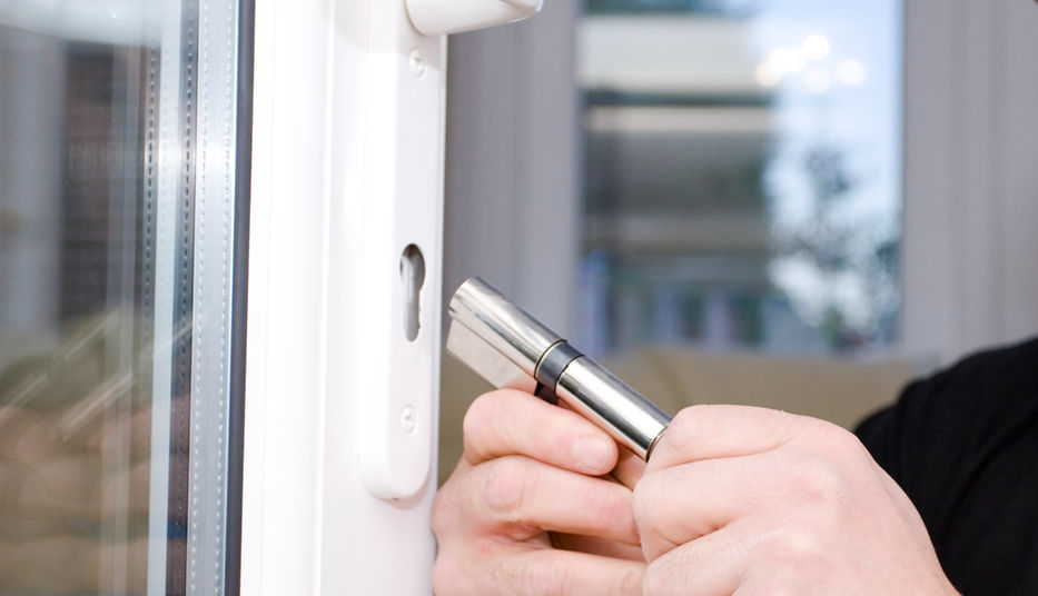 man replacing lock on a window
