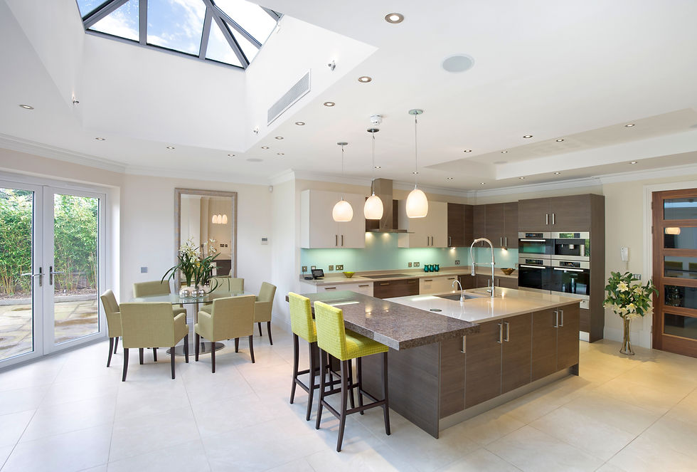 a large kitchen with light dining area in an expensive new home. An island at the centre