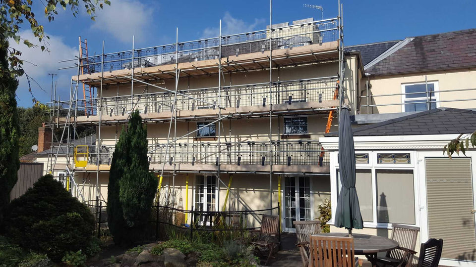 Residential property being painted, scaffolding outside property