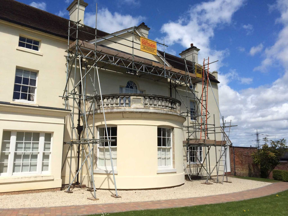 House being painted with scaffolding outside, luxury home