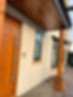 modern house, wooden structure and modern wooden door, smart doorbell visible, freshly rendered walls on property